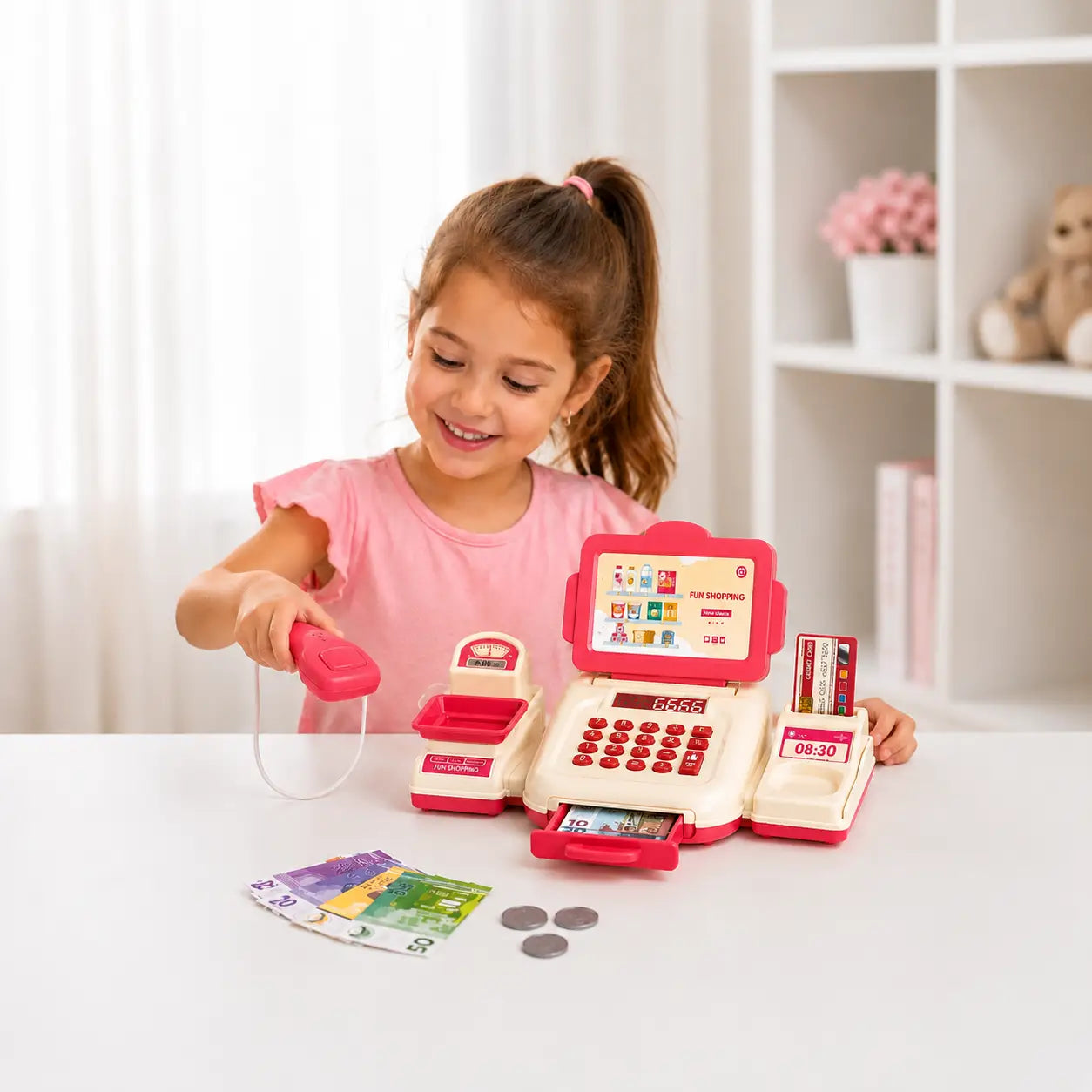 Young girl playing with a kids cash register toy set featuring scanner, keypad, play money and shopping accessories