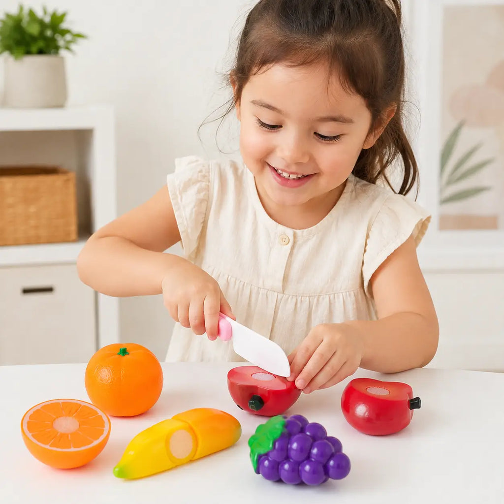 Child playing with colorful kids cutting fruit kitchen toy set using pretend toy knife