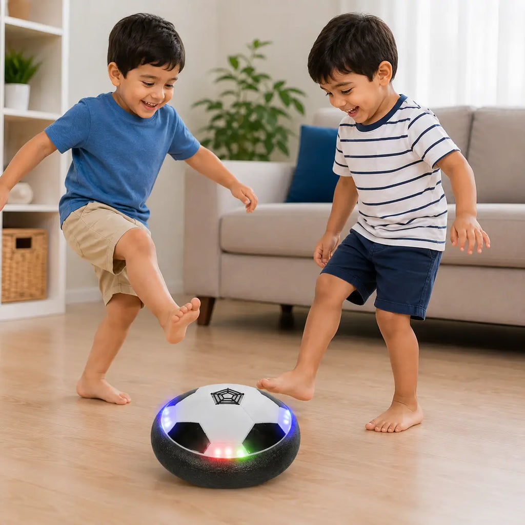 Two children playing indoors with an LED hover soccer ball on a smooth wooden floor