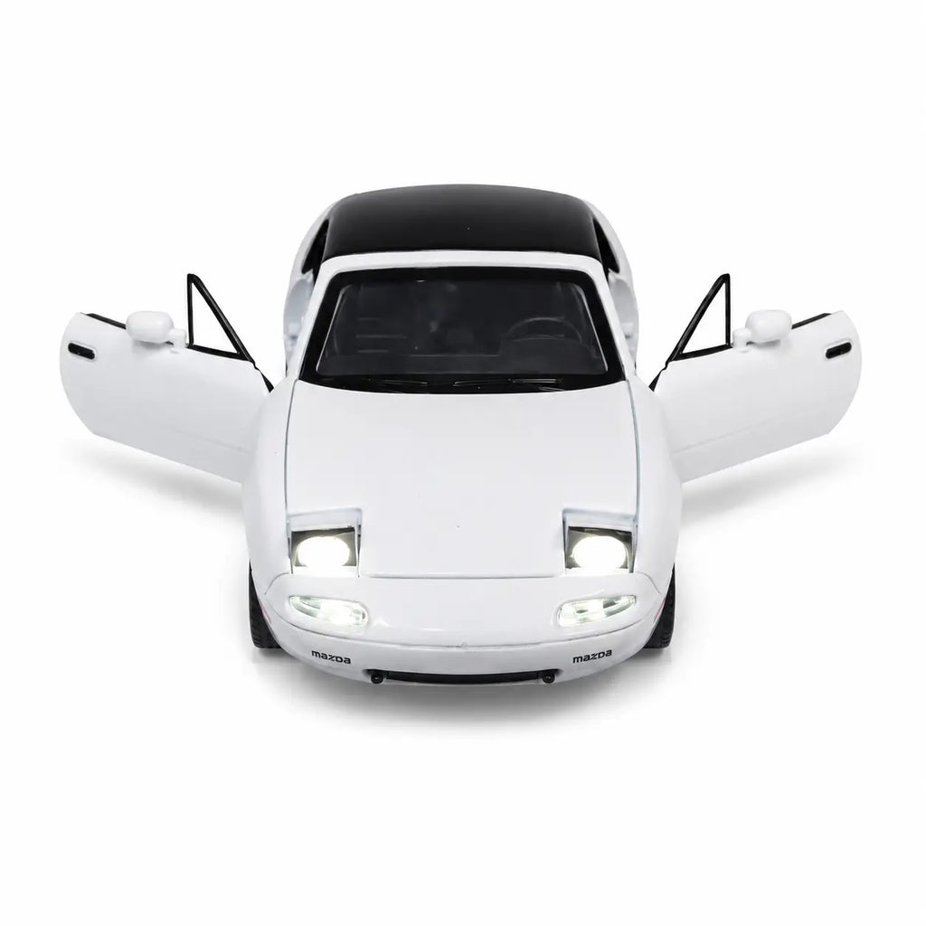 White Mazda MX-5 model car with both doors open and front lights illuminated