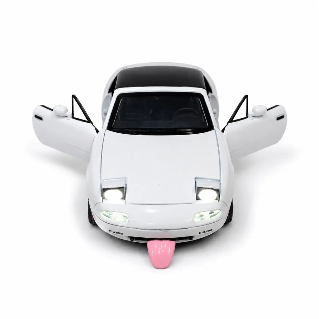 White Mazda MX-5 toy model with open doors, lights on and pink tongue-style feature